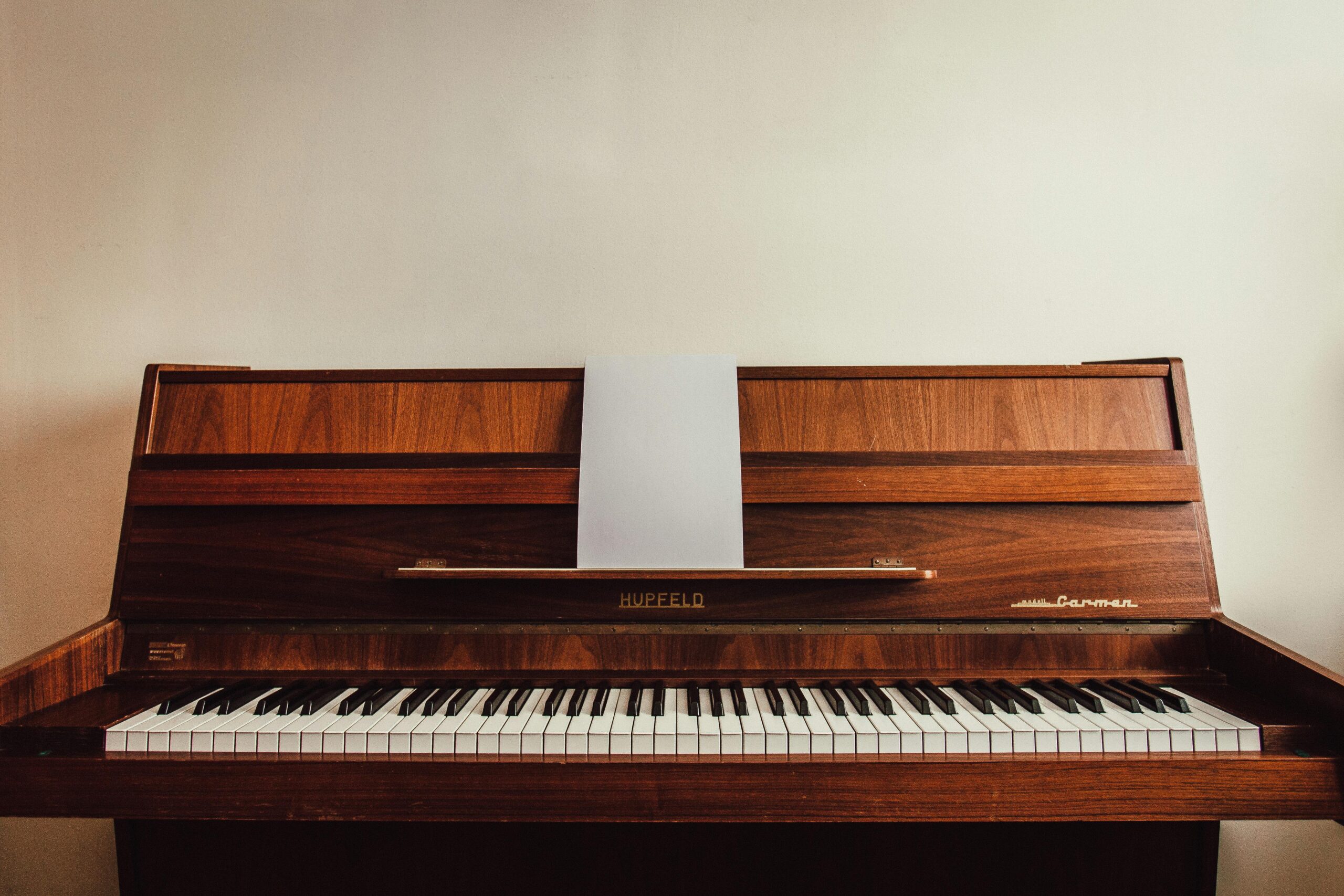 Classic wooden upright piano displaying sheet music, perfect for music lovers.